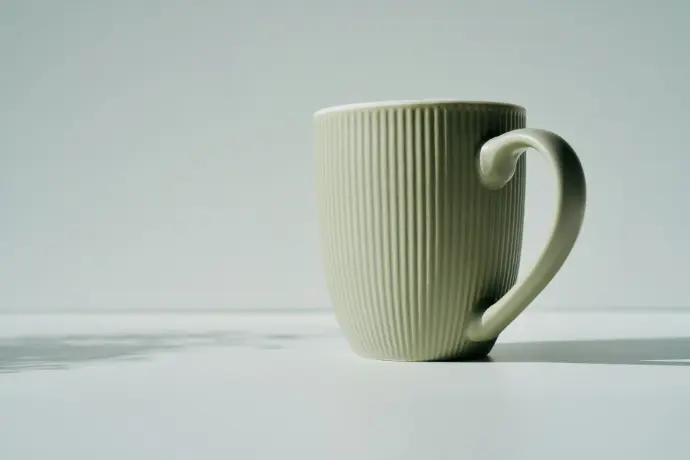 a white coffee cup sitting on top of a table